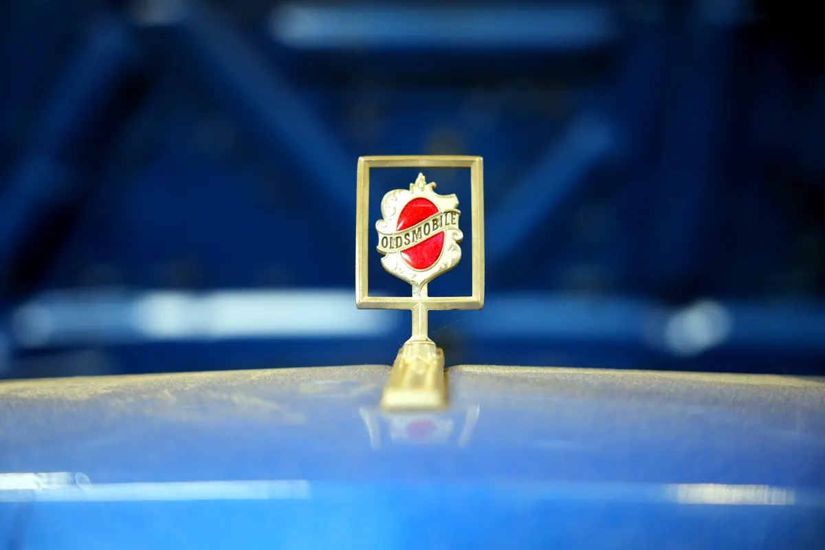 Vintage hood emblem on a metallic blue hood